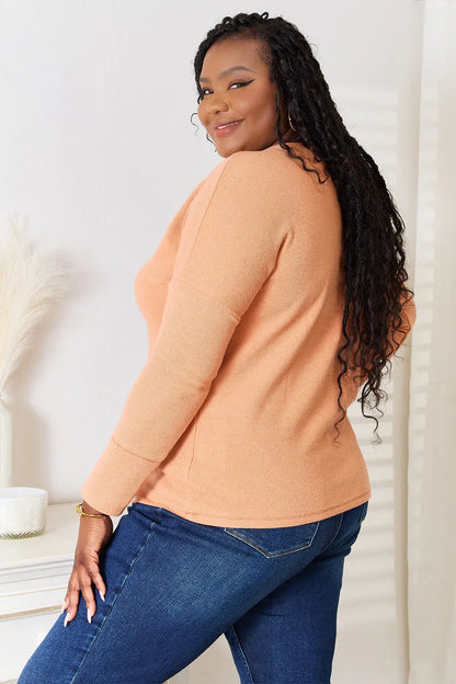 Plus-size woman wearing Basic Bae Half Button Long Sleeve Top with dark blue jeans