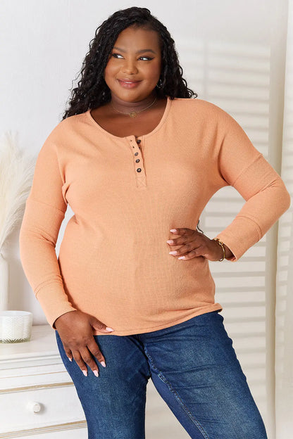 Plus-size woman wearing Basic Bae Half Button Long Sleeve Top with dark wash jeans