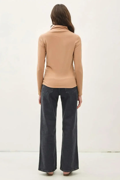 Beige mock neck long sleeve turtleneck sweater with black wide-leg pants
