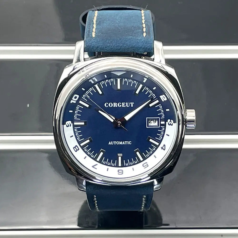 Men’s automatic watch with blue dial, silver-tone case, and blue leather strap on steel black surface