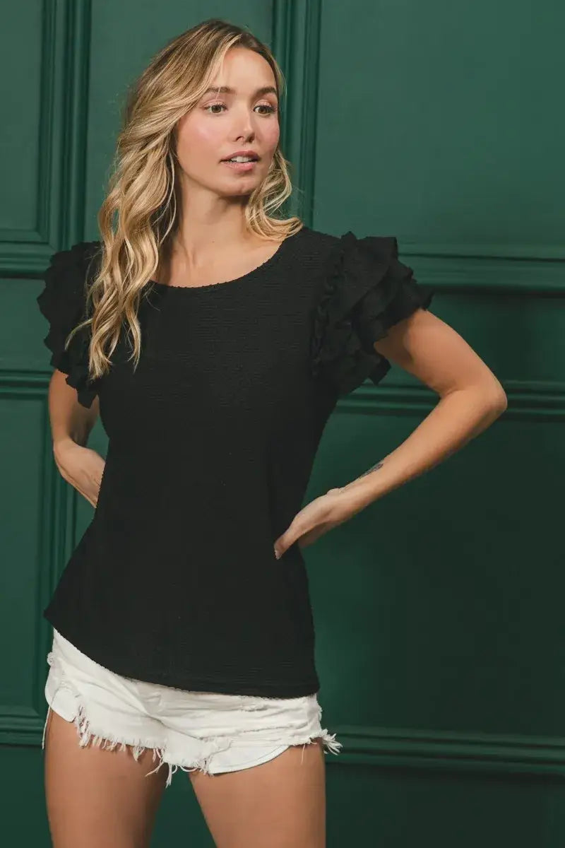 Black ruffled sleeve top with birdseye texture layered design and frayed hem shorts