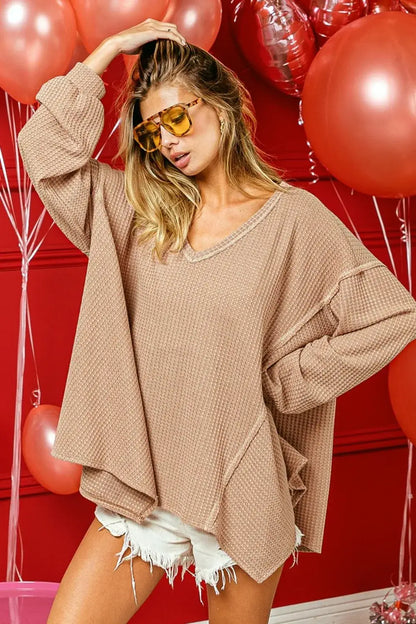 Oversized beige waffle uneven hem top with V-neck and raw hem for a cozy look