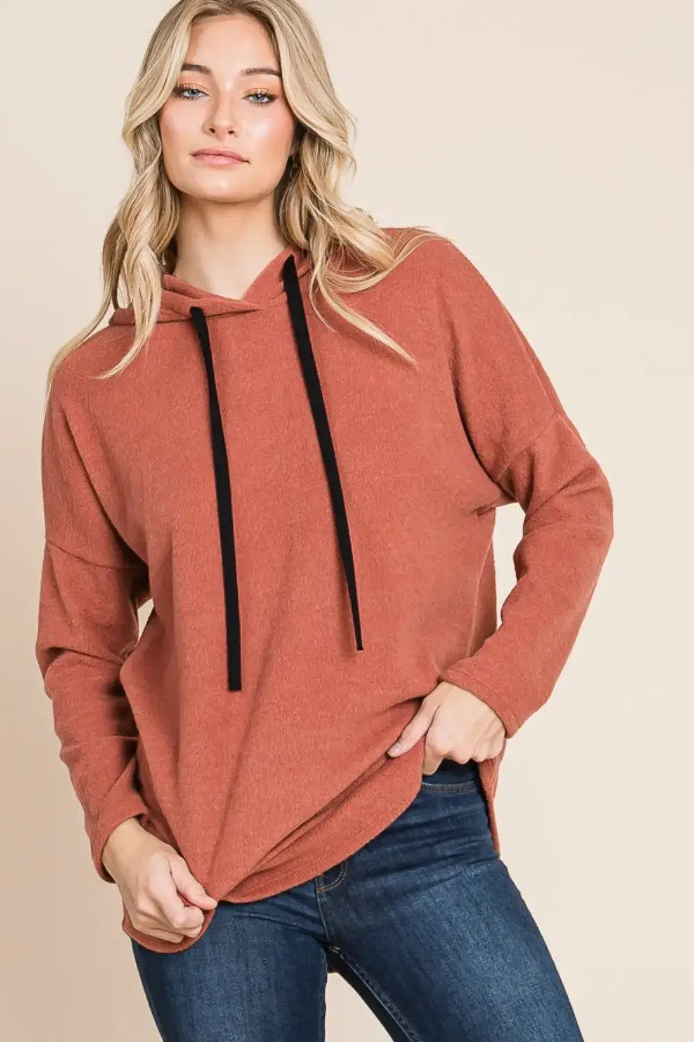 Terracotta knit hoodie with black drawstrings and pockets, relaxed-fit knit casual wear