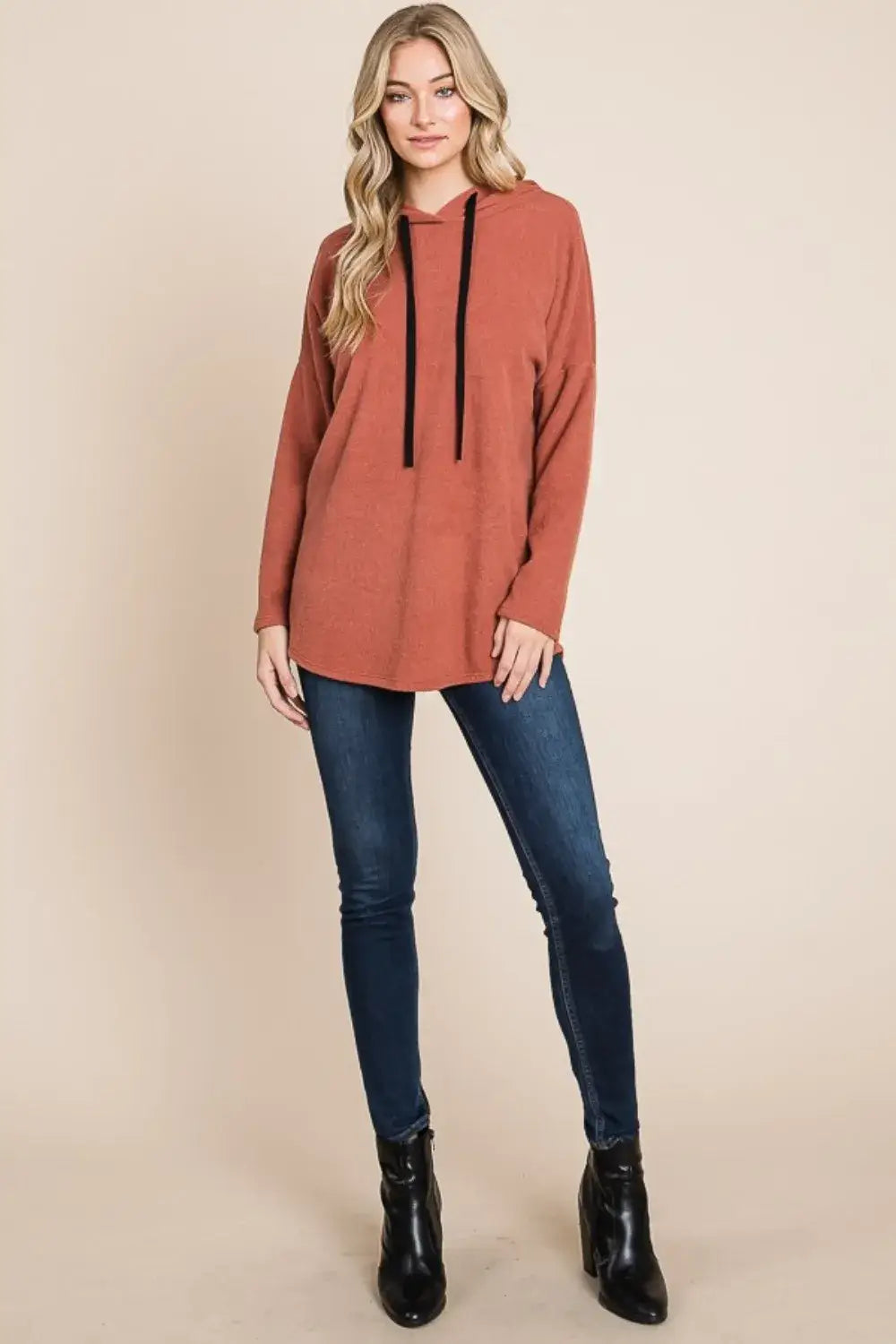 Rust-colored knit hoodie with black drawstrings and long sleeves, relaxed-fit knit hoodie