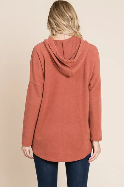 Terracotta knit hoodie with drawstring hood and long sleeves, relaxed-fit knit hoodie style