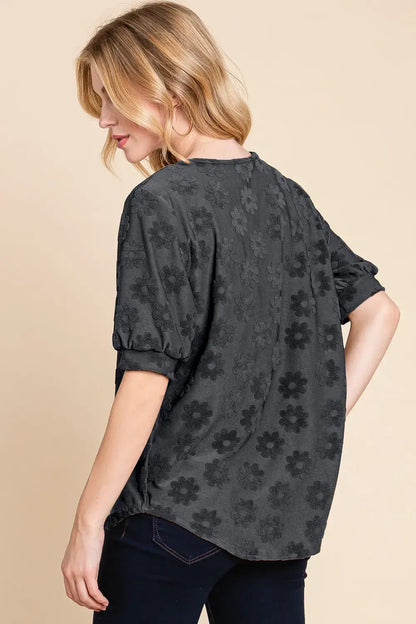 Black floral print blouse with textured floral pattern and rolled sleeves, relaxed fit