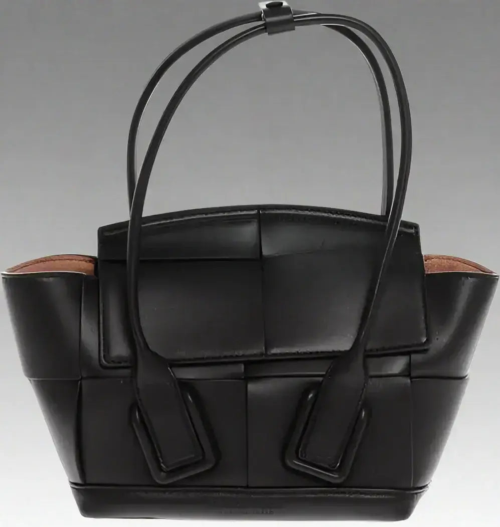 Black leather woven tote bag with top handles and removable shoulder strap