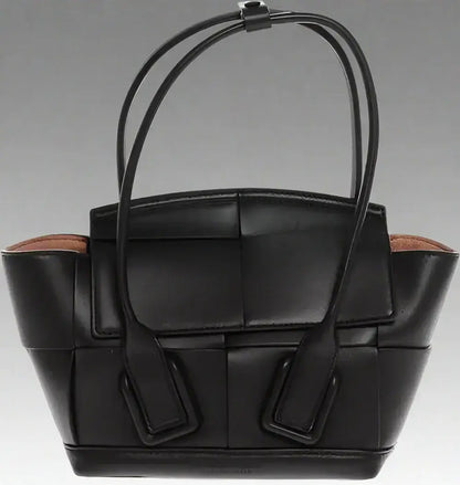 Black leather woven tote bag with top handles and removable shoulder strap