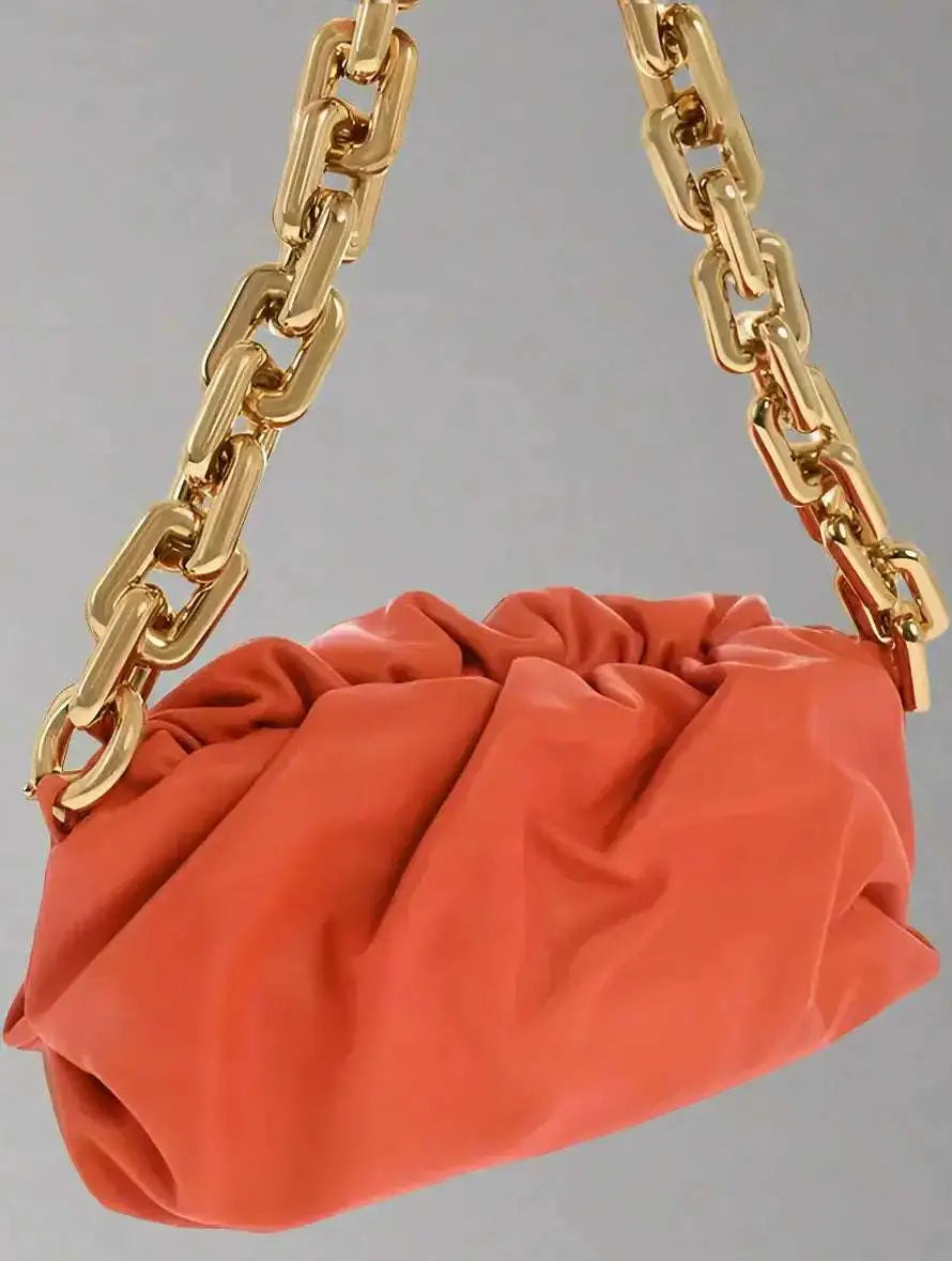Orange Bottega Veneta chain pouch bag with chunky gold chain strap and magnetic closure