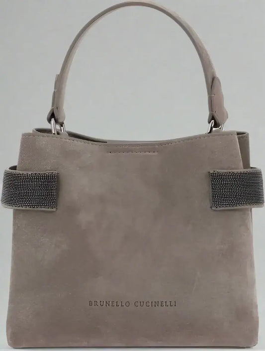 Light brown suede leather handbag with top handle and embellished side straps