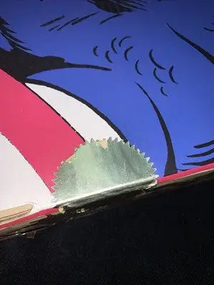 Damaged serrated metal picture hanger attached to artwork in Captain America Marvel figure set
