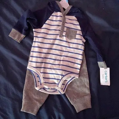 Newborn baby boy in Carter’s gray and blue striped hooded bodysuit with gray pants