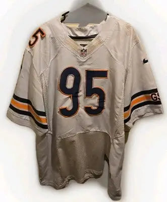 Worn white Chicago Bears jersey with missing numbers, tears, and discoloration