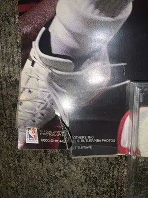 Damaged glossy photo of a Chicago Bulls player’s foot with NBA logo, sports memorabilia