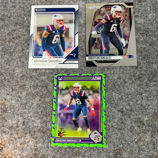 Three Christian Gonzalez New England Patriots 2024 NFL football trading cards displayed