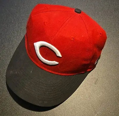 Red and black Cincinnati Reds baseball cap with small writing inside and white C logo