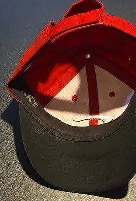 Red and black Cincinnati Reds baseball cap with small writing inside for sale