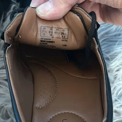 Interior of a black leather dress shoe with size tag for Clarks Men’s Size 8.5 Oxford