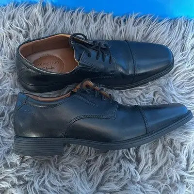 Two pairs of men’s black leather cap-toe dress shoes for formal occasions