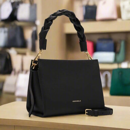 Black leather handbag with braided top handle and adjustable shoulder strap for women