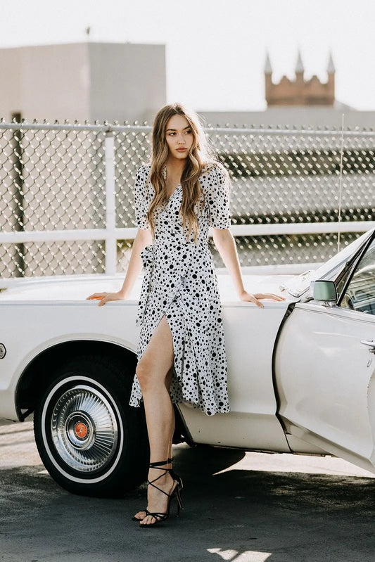 Woman in Coco Dress White Polka Dot with black lace-up heels, perfect for business days