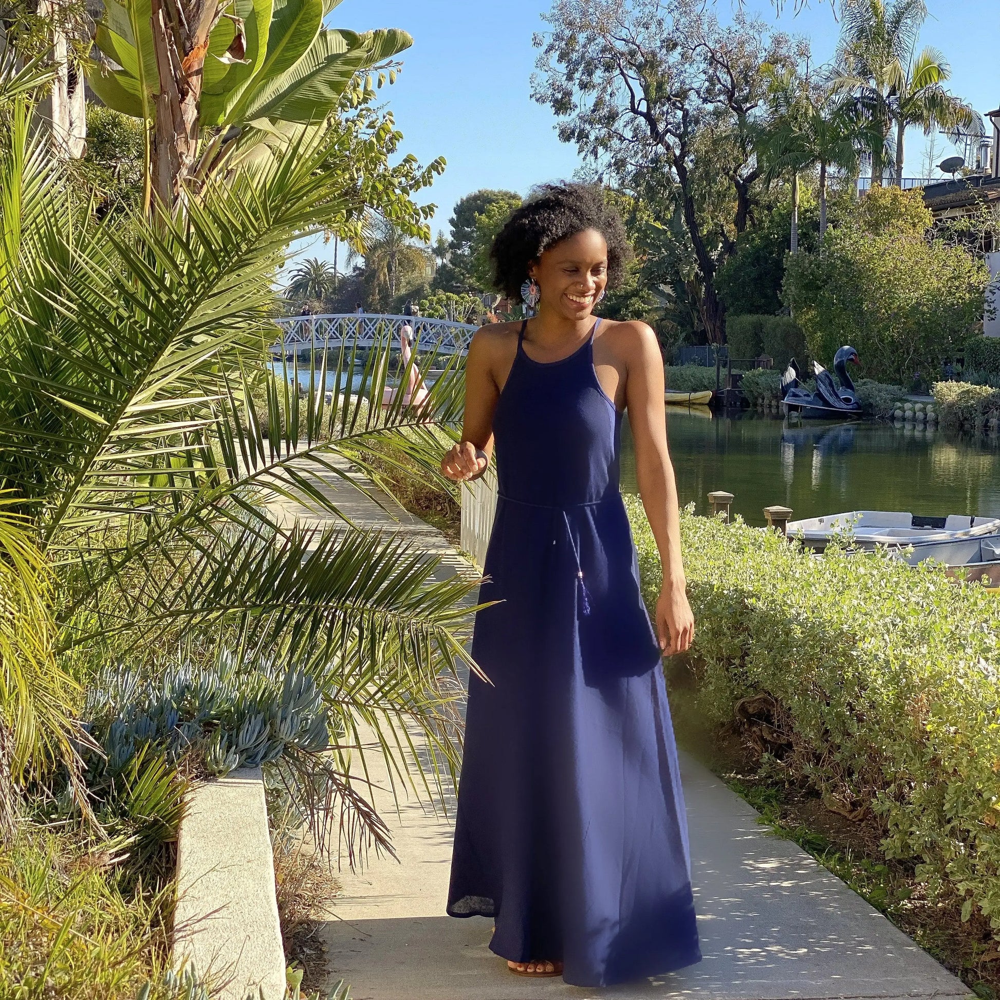 Smiling woman in navy cotton silk long maxi dress with halter-neck and drawstring waist