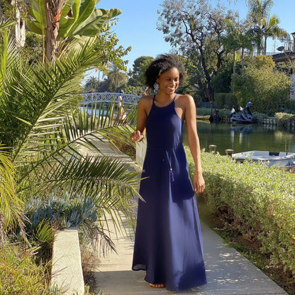 Smiling woman in navy cotton silk long maxi dress with halter-neck and drawstring waist