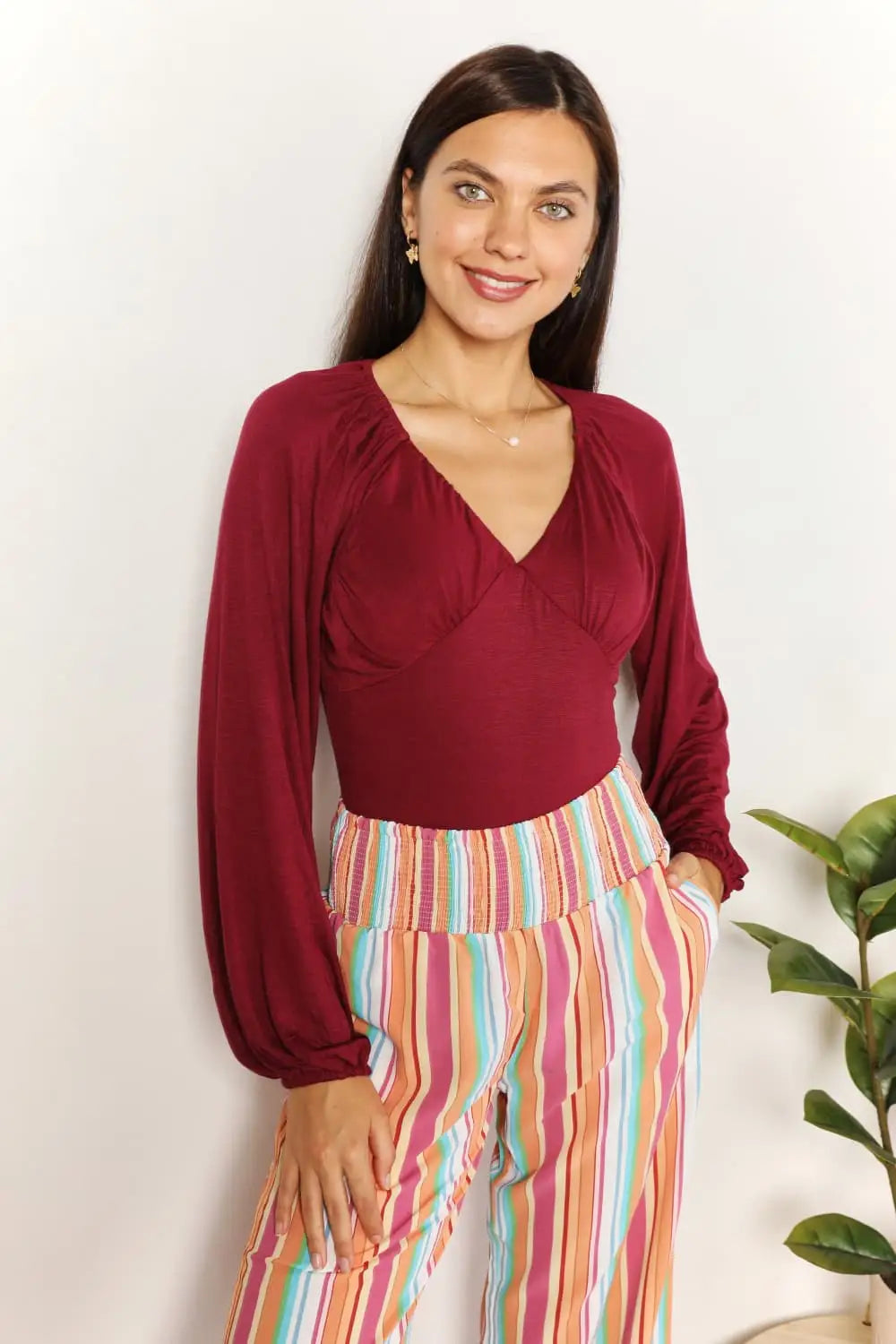 Culture Code full size v-neck bodysuit with burgundy ruffled poet sleeves and colorful striped pants