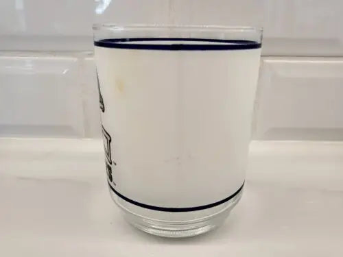 White frosted glass tumbler with blue trim and Dallas Cowboys helmet logo design