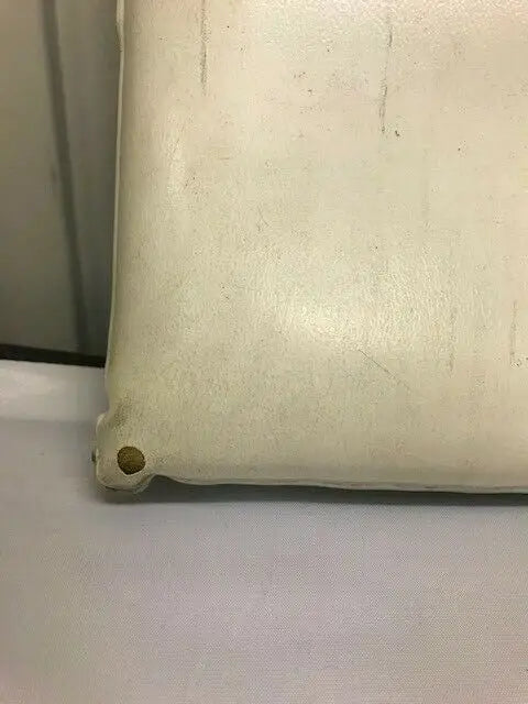 Cream-colored worn Dallas Cowboys seat cushion with a hole from Texas Stadium
