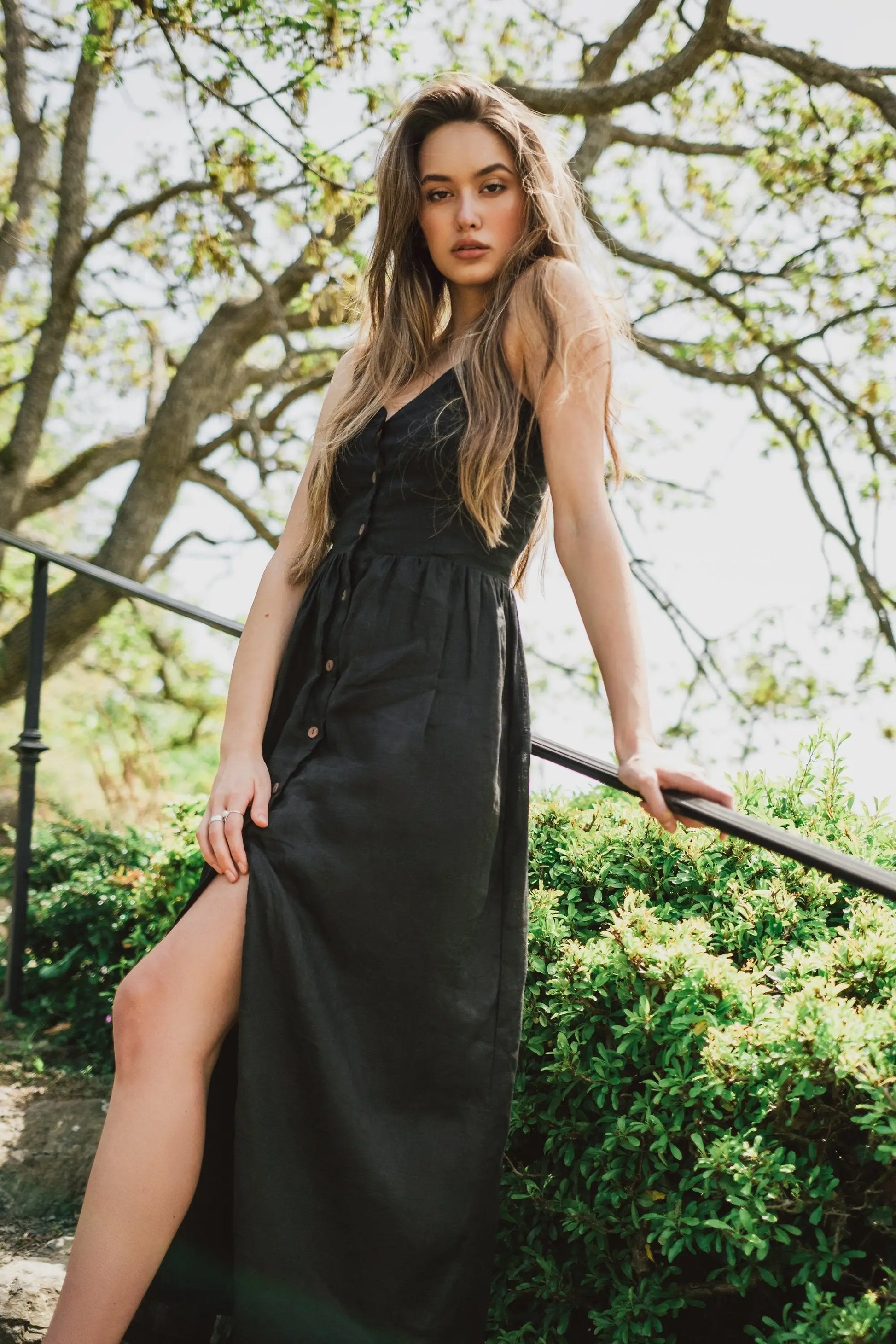 Young woman in Daria Linen Dress Black with side slit and buttons, perfect for business days