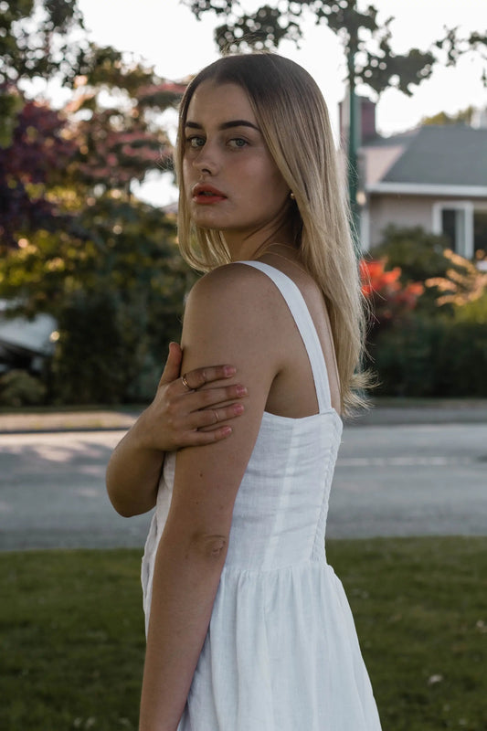 Young woman in white Daria Linen Dress wearing a stylish linen dress for summer days