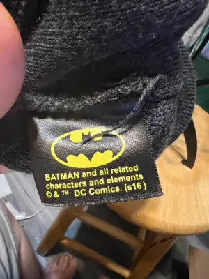 Black fabric tag with yellow Batman logo and copyright info on DC Comics Batman Beanie Hat