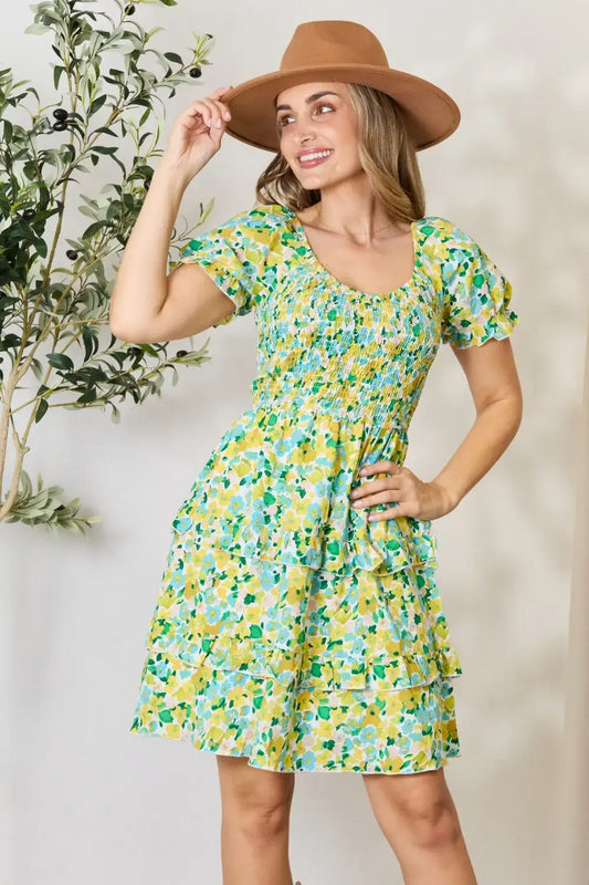 Woman wearing Devine Smocked Scoop Neck Mini Dress with floral print and brown fedora