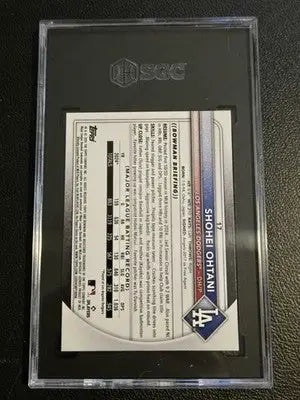 Baseball trading card in protective slab with Roki Sasaki card and New Era 9FIFTY Snapback