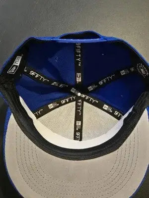 Blue baseball cap with gray brim and black sweatband, Era 9FIFTY snapback style