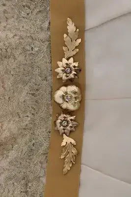 Gold silk dress with crystal embellished floral and leaf embellishments on tan fabric strip