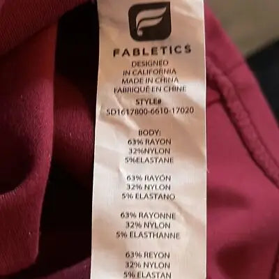 Red Fabletics clothing tag with fabric details for Burgundy Short Sleeve Dress rear zip