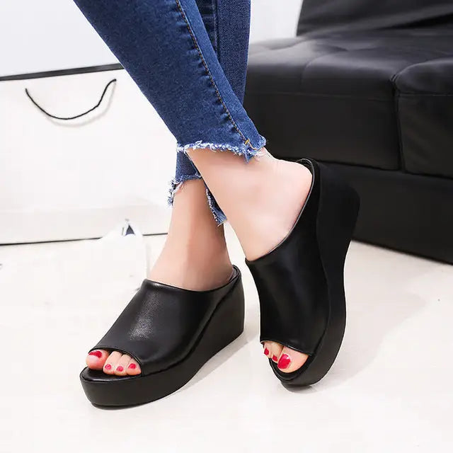 Fashionable women’s high heel fish mouth sandals with black open-toe wedges and distressed jeans