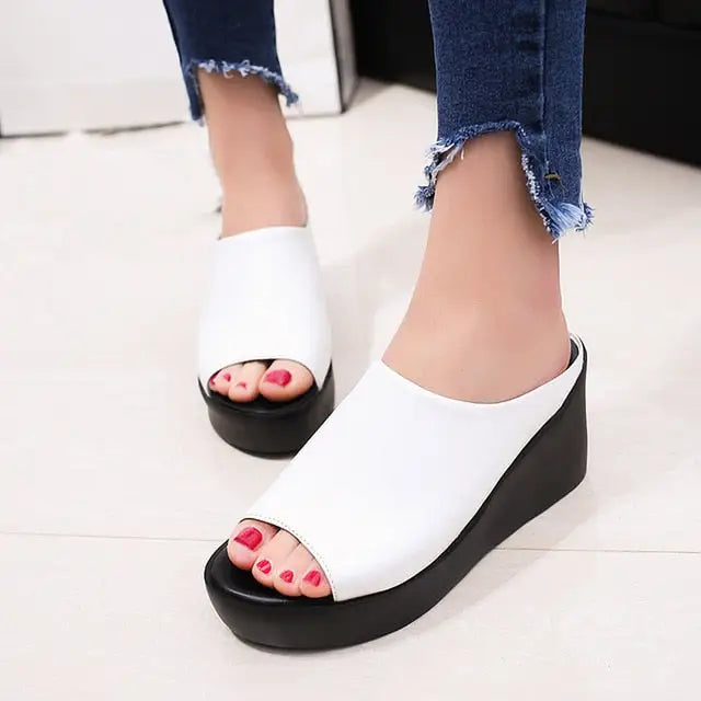 Fashionable women’s high heel fish mouth sandals with open toes, red nail polish, and frayed denim