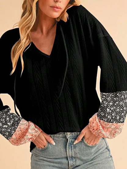 Black floral patchwork long-sleeve top with V-neckline and floral print cuffs