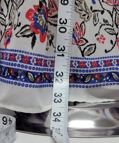 White fabric with floral and geometric pattern being measured, perfect for bohemian long sleeve floral dress