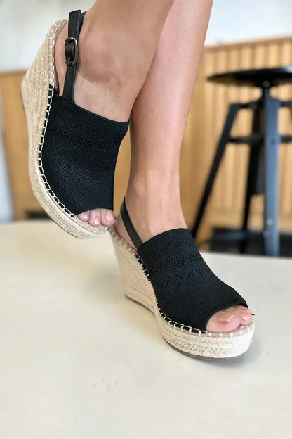 Black espadrille wedge sandal with woven sole and ankle strap for peep toe high heel style
