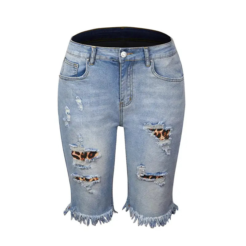 Light wash distressed denim shorts with leopard patches, frayed hems, and ripped holes