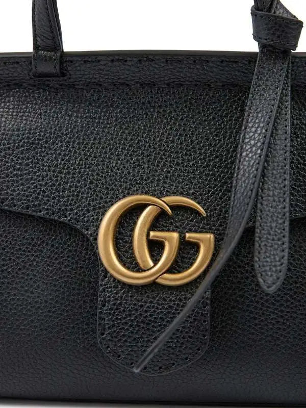 Black leather Gucci GG Marmont handbag with gold GG logo for luxury fashion style