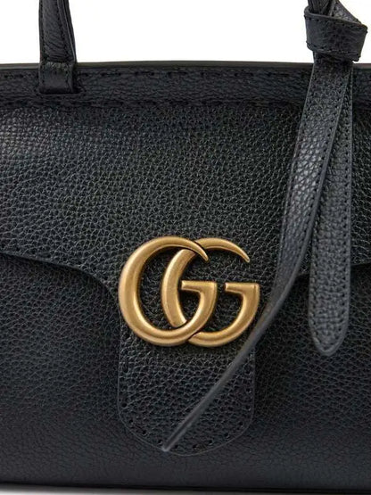Black leather Gucci GG Marmont handbag with gold GG logo for luxury fashion style