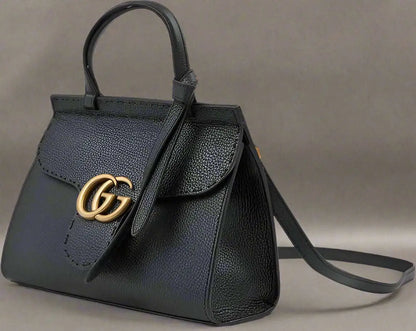Black leather GG Marmont handbag with gold GG logo and shoulder strap