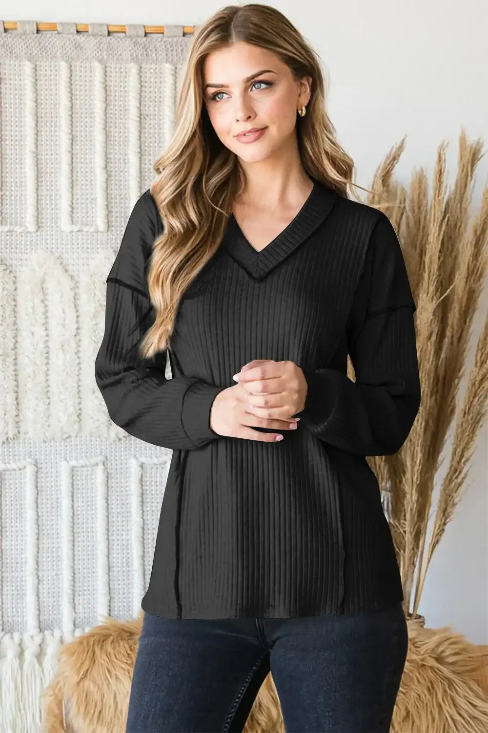Black ribbed V-neck exposed seam sweater with bell sleeves and relaxed fit