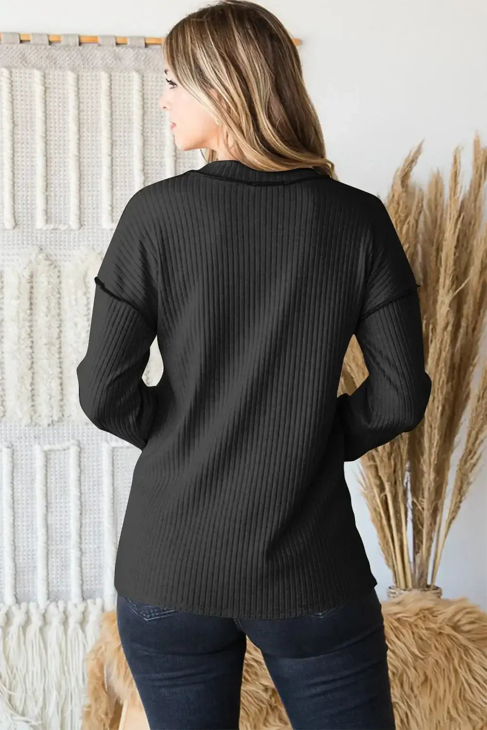 Black ribbed knit cardigan with v-neck exposed seam and cowl neck detail