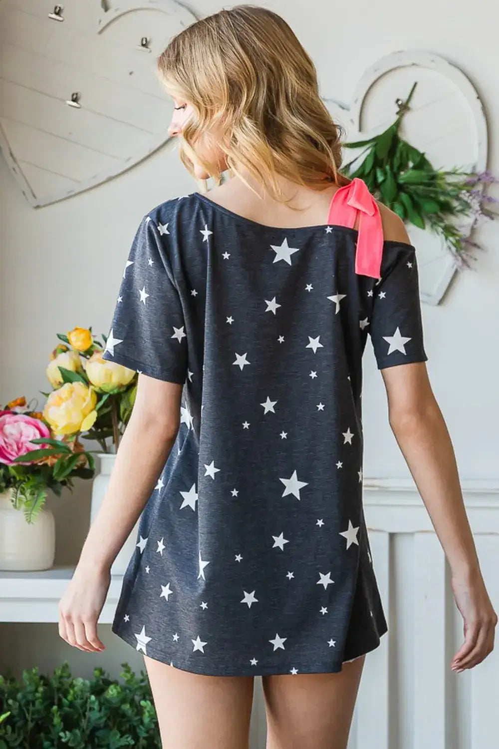 Dark grey star print asymmetrical short sleeve top with pink bow on shoulder